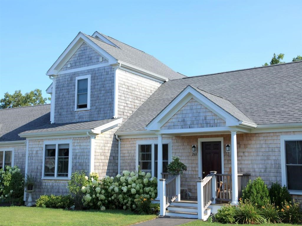a white house with a gray roof and a porch