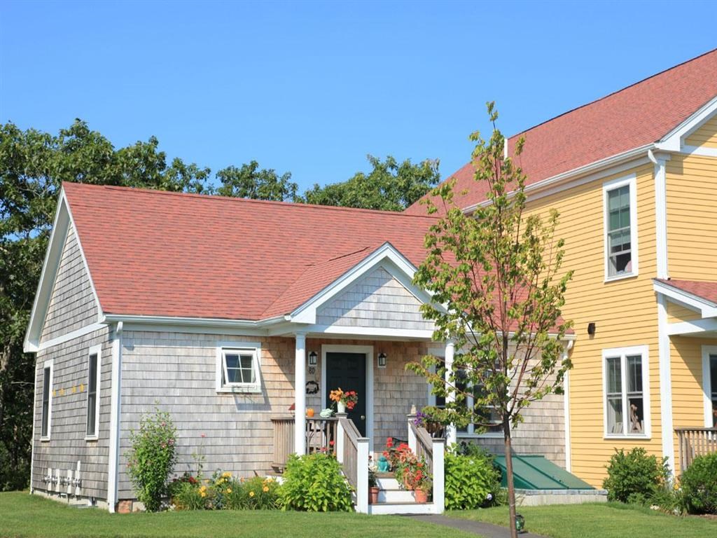 a house with a red roof next to a yellow house
