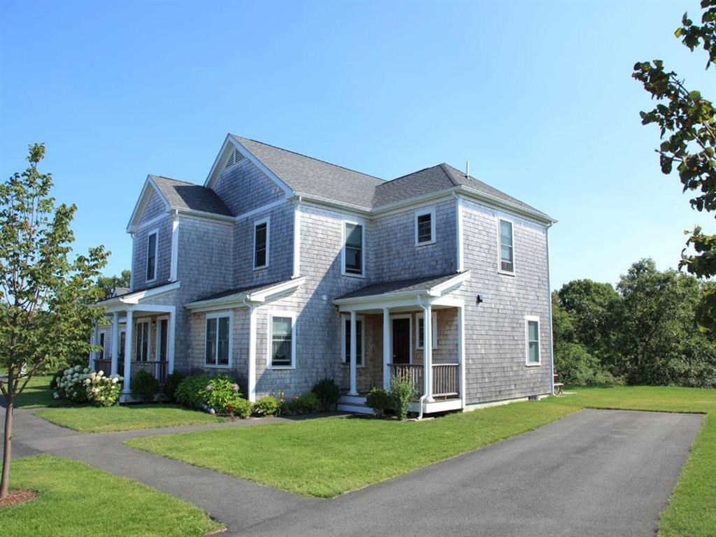 a blue house with a gray roof and a driveway