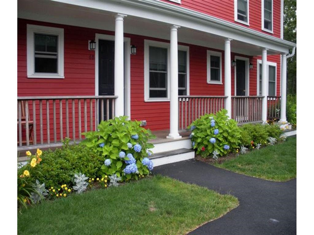 a red house with a porch and flowers on it