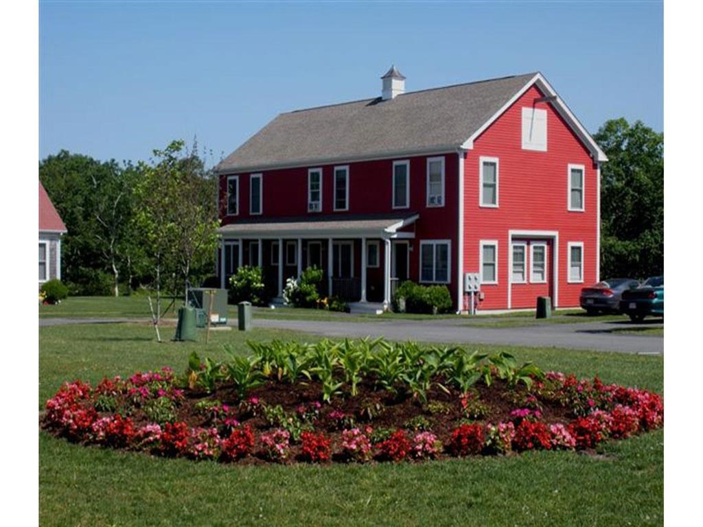 a red house with a flower garden in front of it