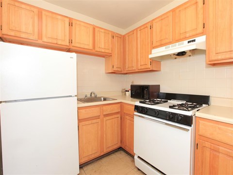 a kitchen with white appliances and wooden cabinets