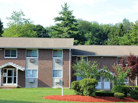 the front of a brick house with a manicured yard