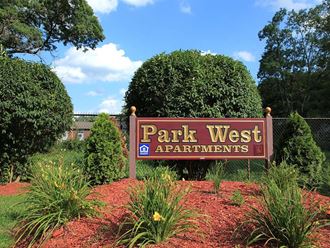 a park west apartments sign in front of trees