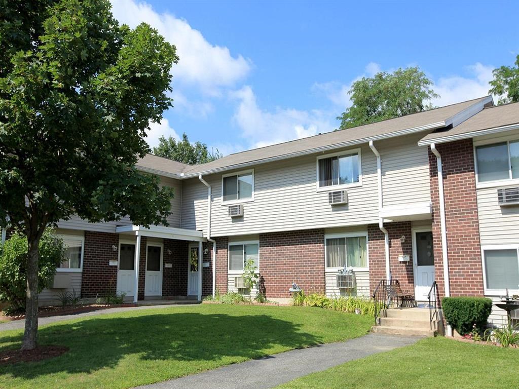 an apartment building with a lawn in front of it
