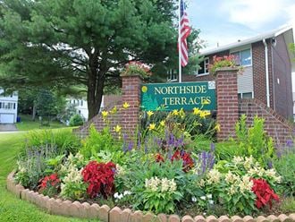 a flower garden in front of a school sign
