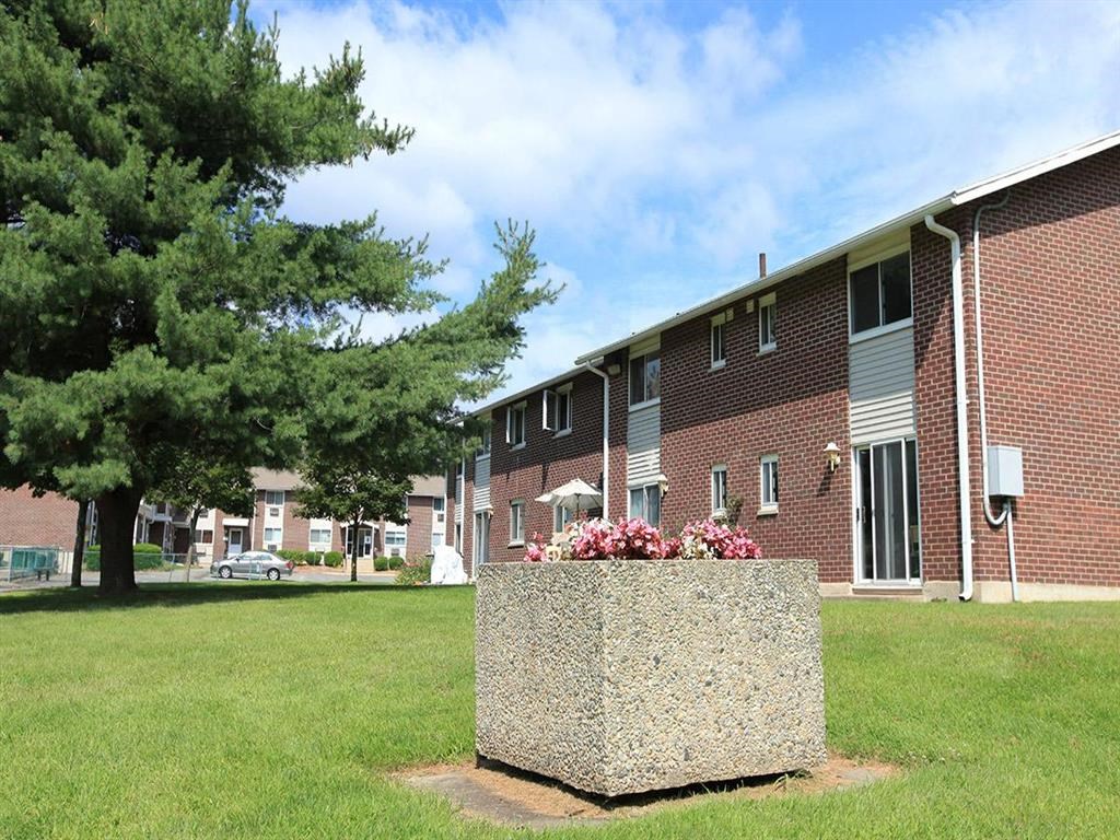 a large stone planter in front of a brick building