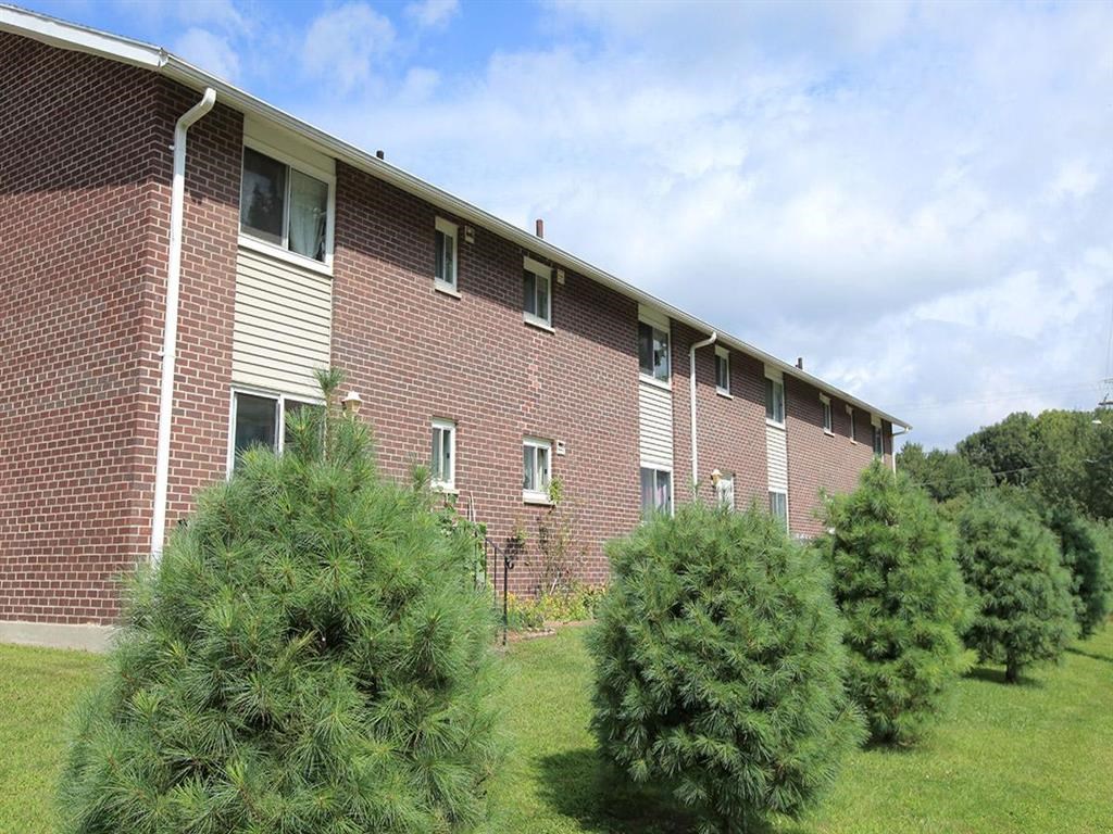 a brick building with trees in front of it
