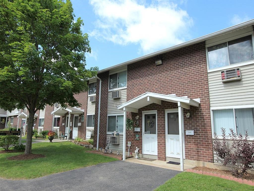 the front of a brick apartment building with a white door