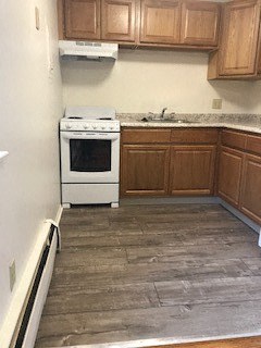 a kitchen with wooden floors and a stove and a sink
