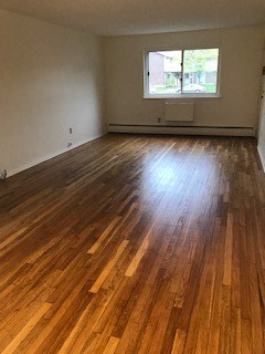 a living room with a hard wood floor and a window
