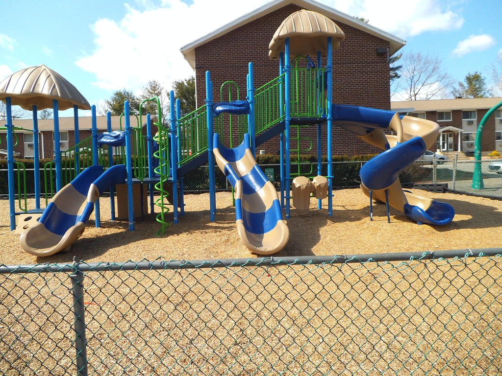 a playground at a school with blue and yellow slides