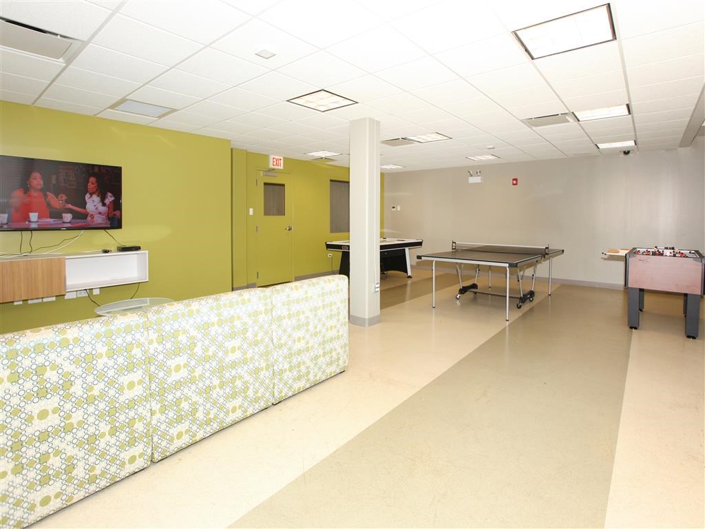 a game room with a ping pong table and a couch