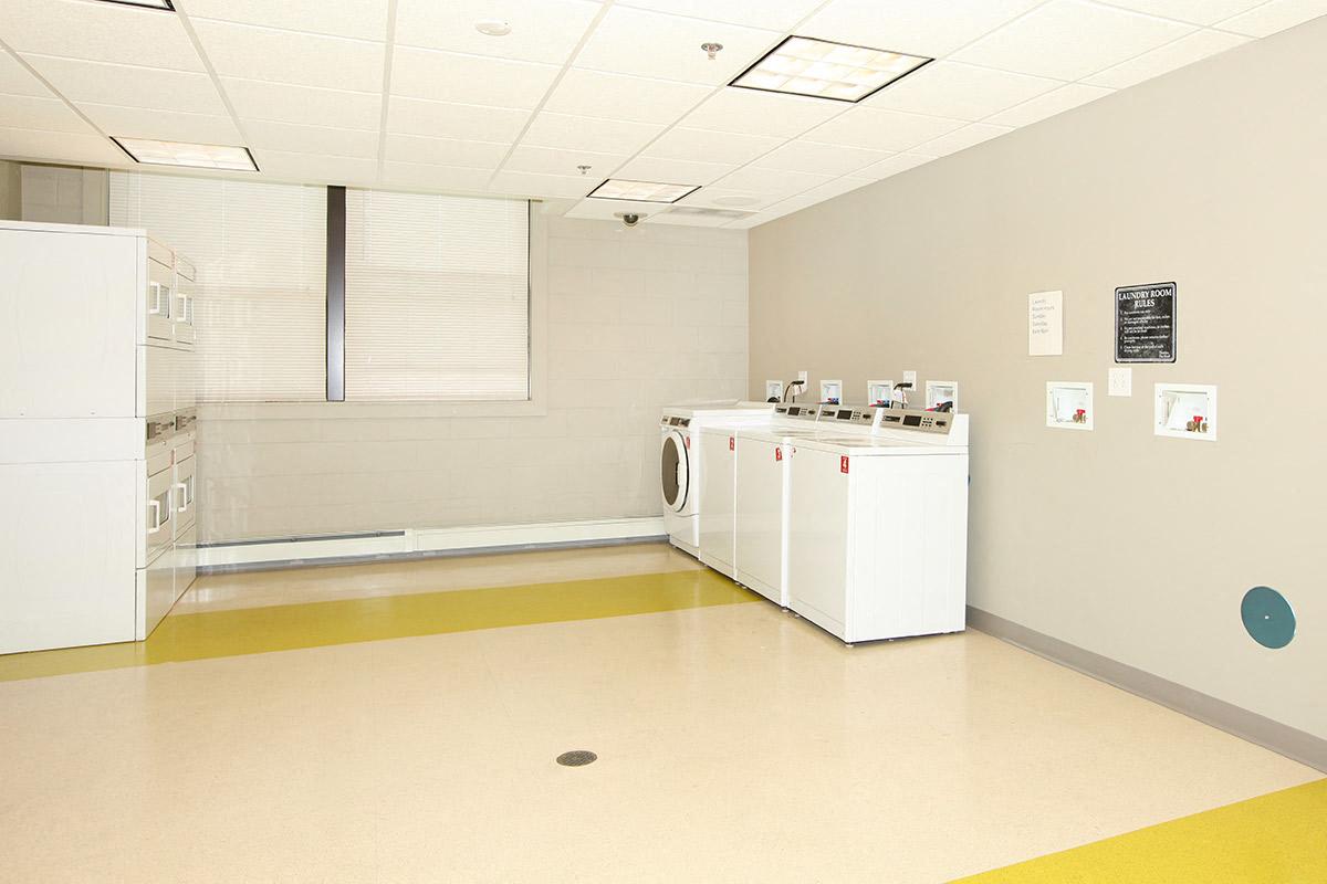 a large room with two refrigerators and a washing machine