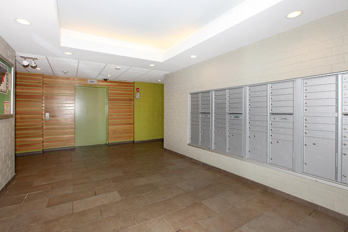 a large room with lockers and a green door