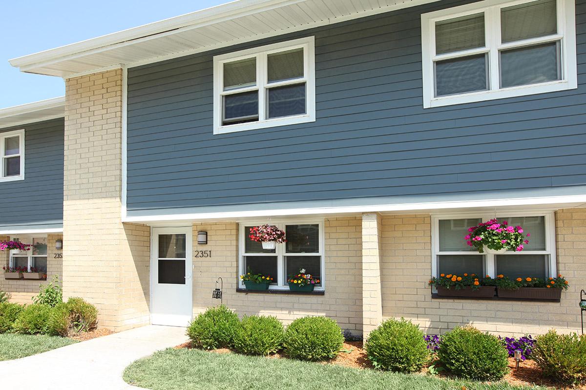 a blue house with flowers in the windows