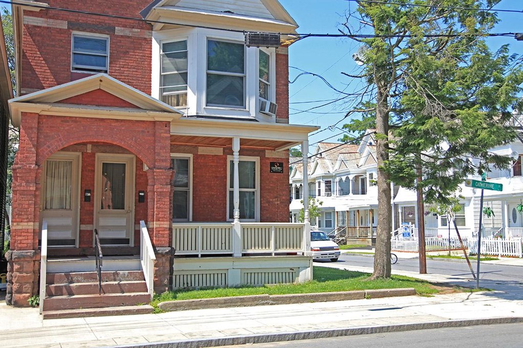 a red brick house on the corner of a street