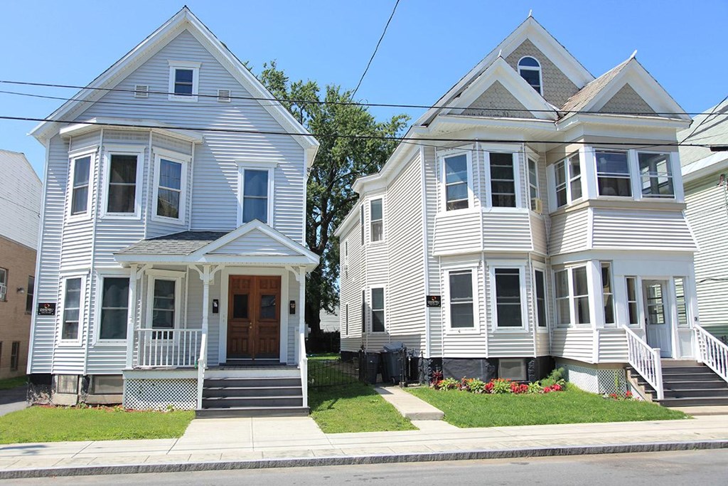 two white houses on the corner of a street
