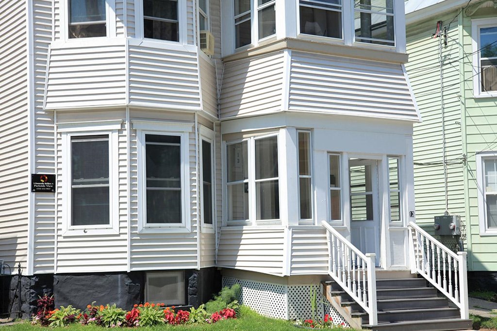 a white house with white siding and a white porch