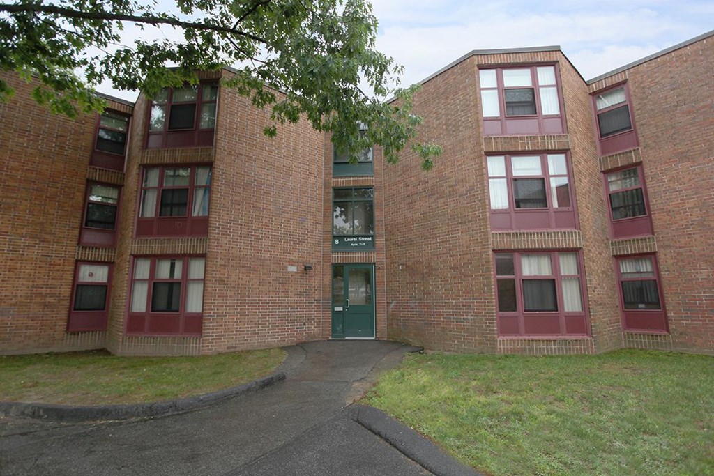 the front of a brick building with a green door