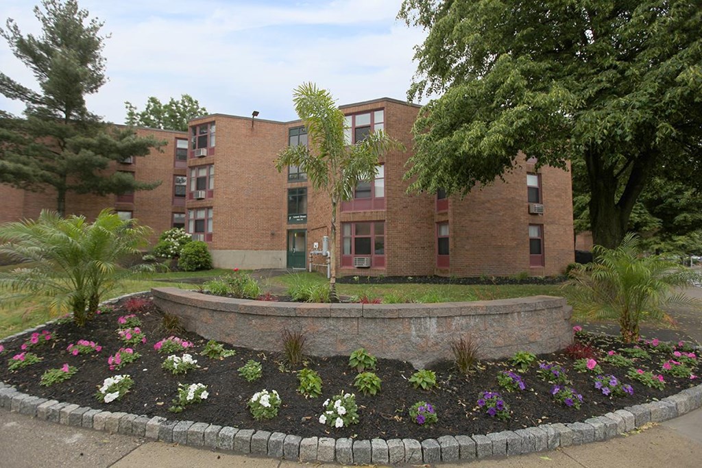 a garden in front of a brick building