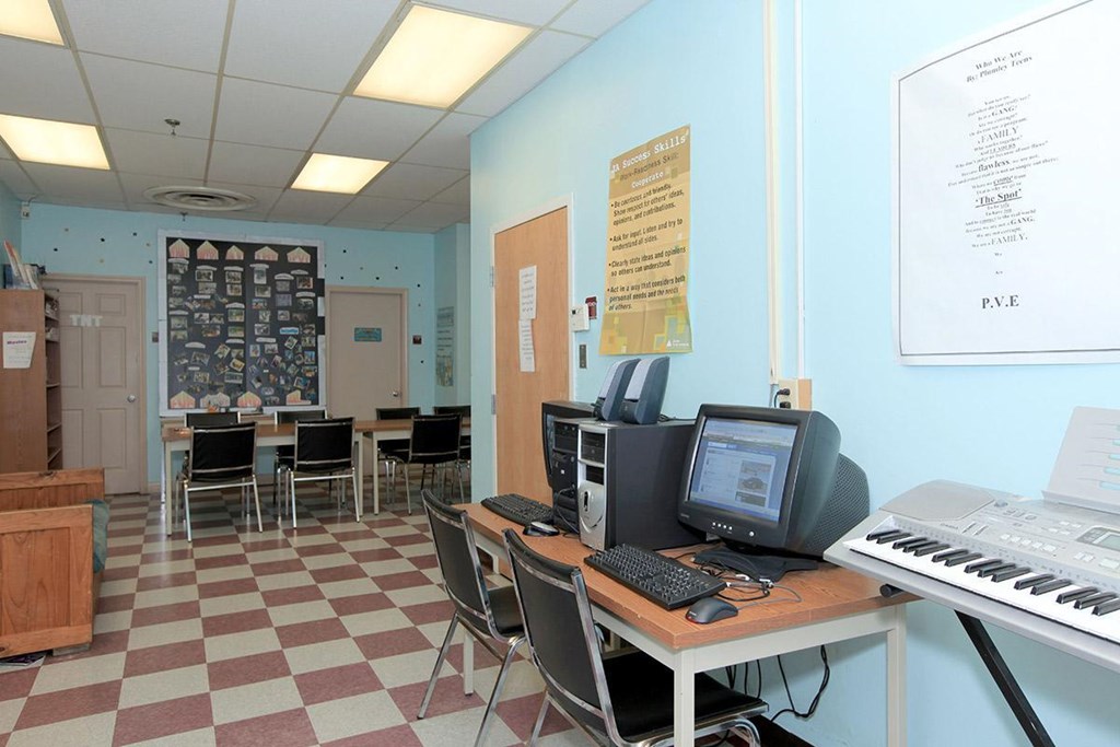 a classroom with a computer and a keyboard on a desk