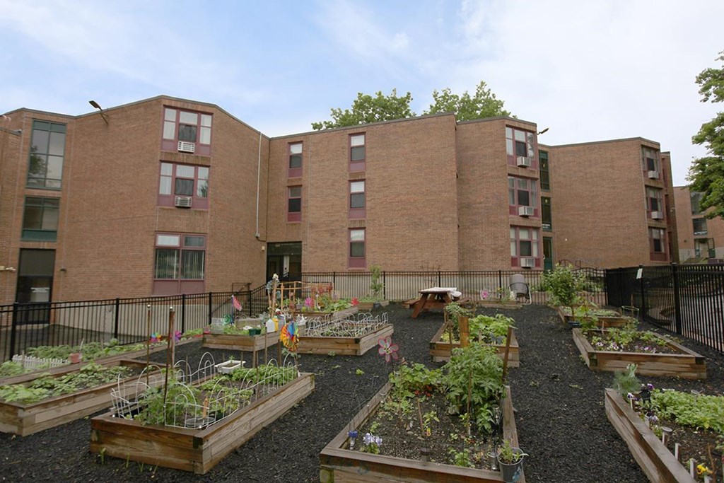 a community garden in front of a brick building