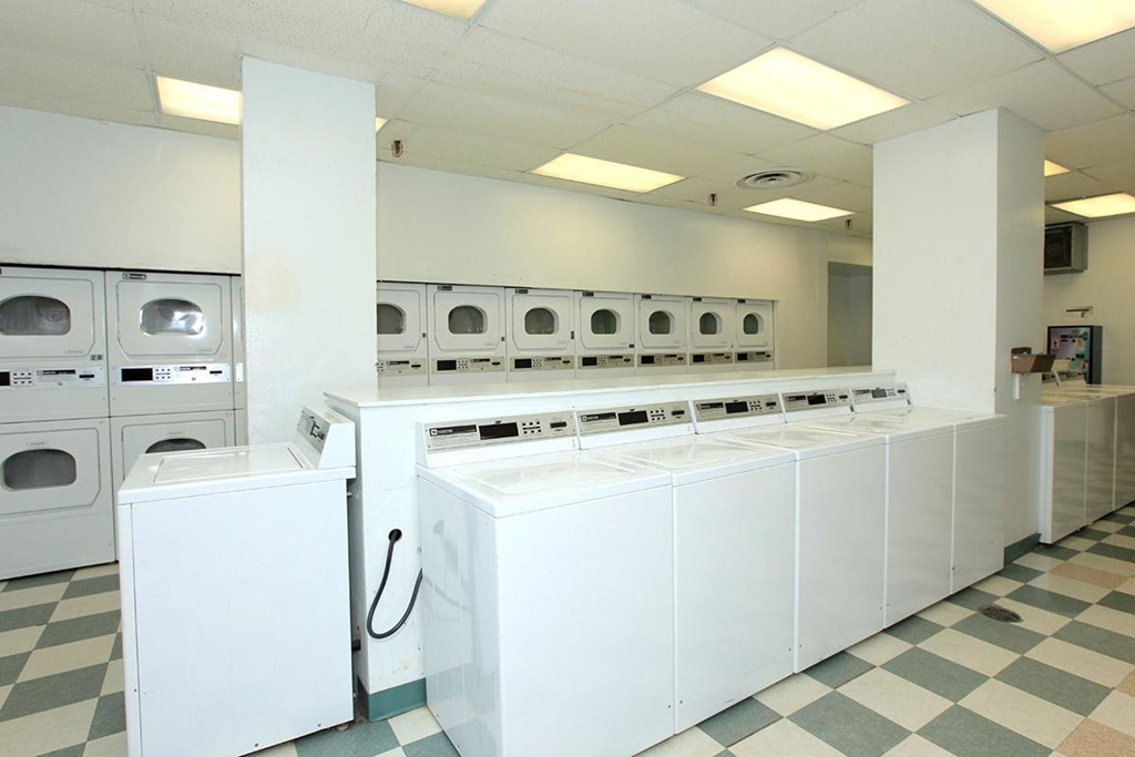 a bunch of washers and dryers in a laundry room