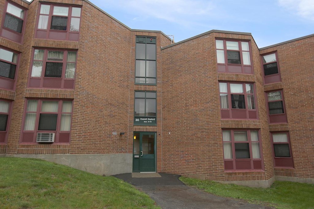 the front of a brick building with a green door