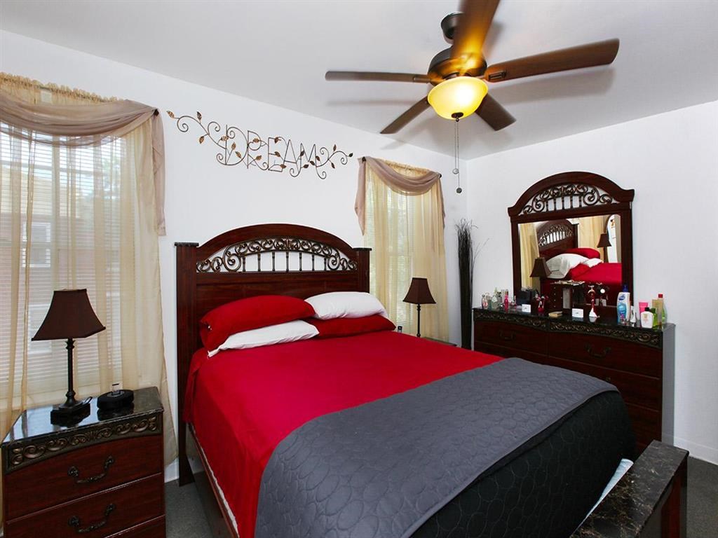 a bedroom with a bed and a ceiling fan