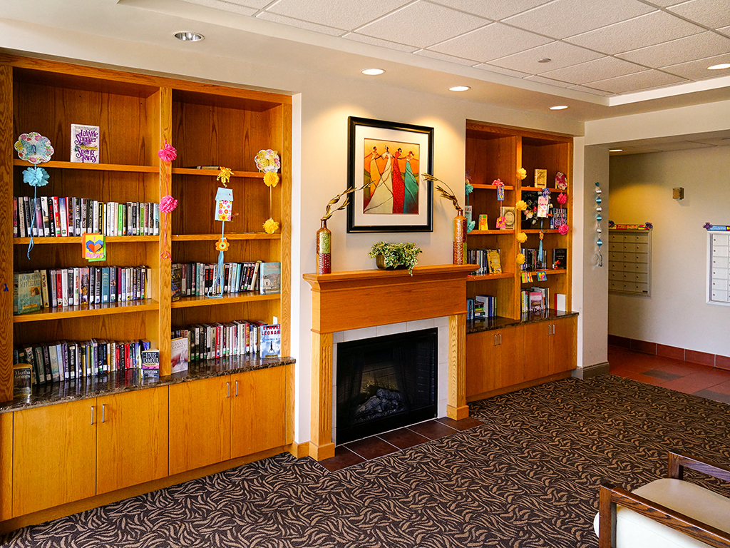 a library with a fireplace and bookshelves