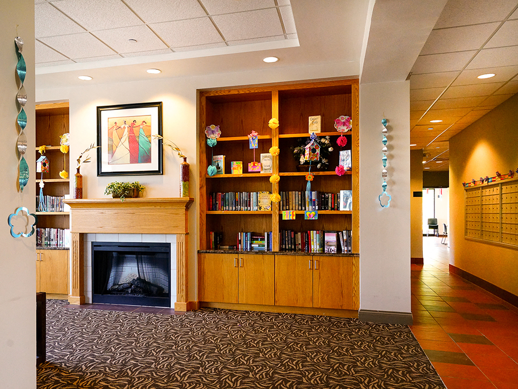 a lobby with a fireplace and bookshelves