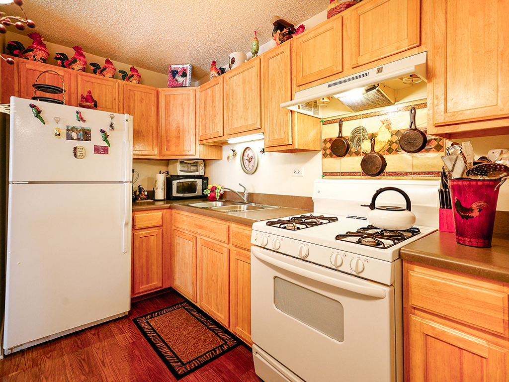a kitchen with white appliances and wooden cabinets