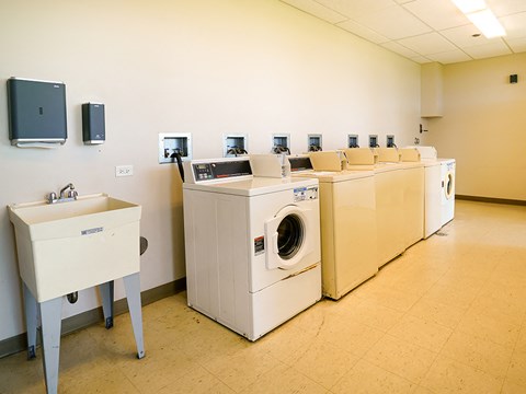 a washer and dryer room with a row of washing machines