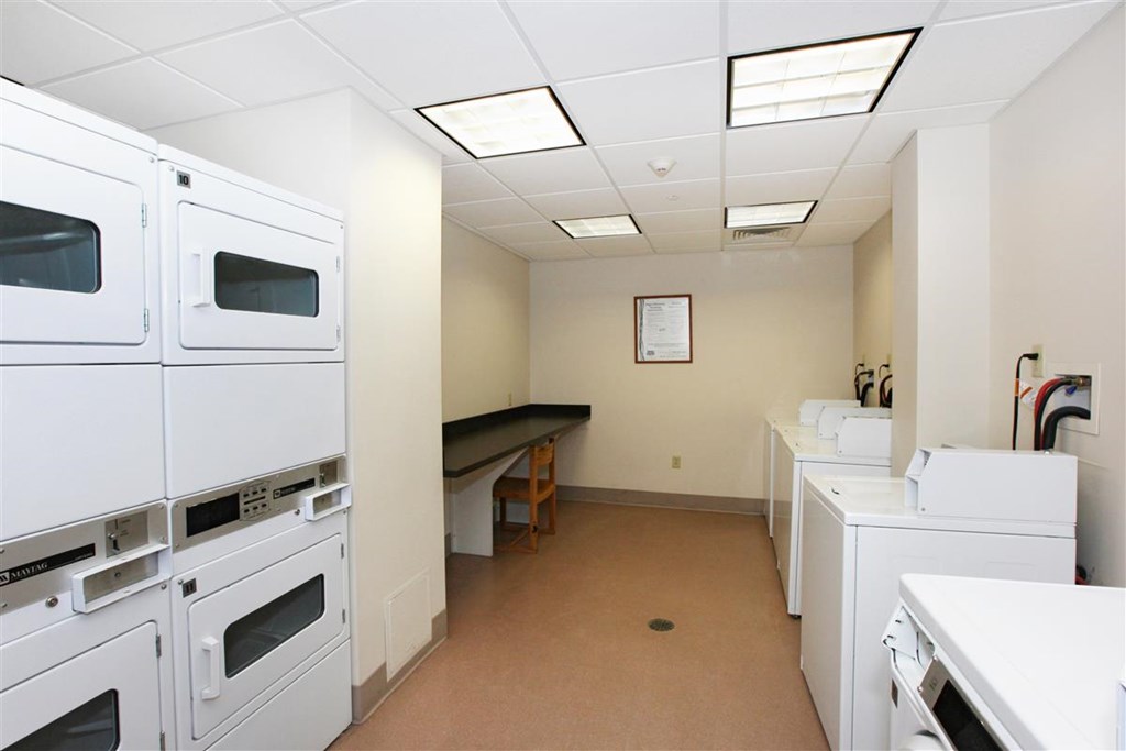 a laundry room with dryers and other appliances in it