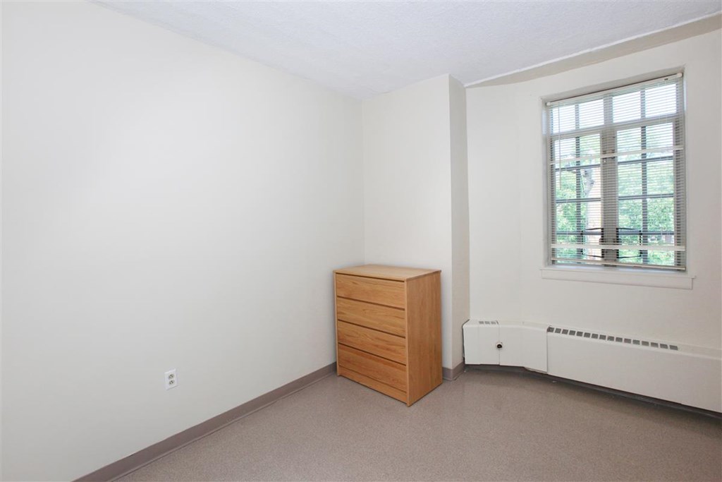 a bedroom with a dresser and a window