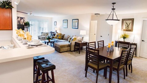 a living room and dining room with a table and chairs