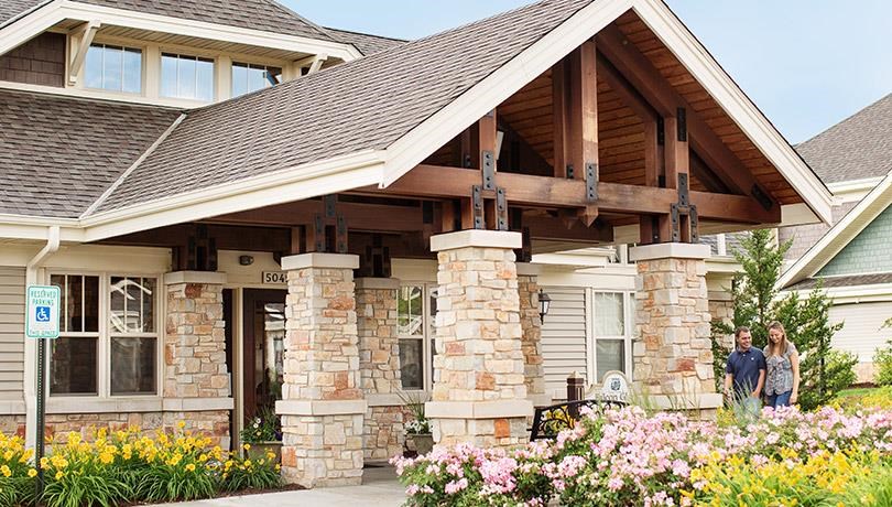 two people standing in front of a house