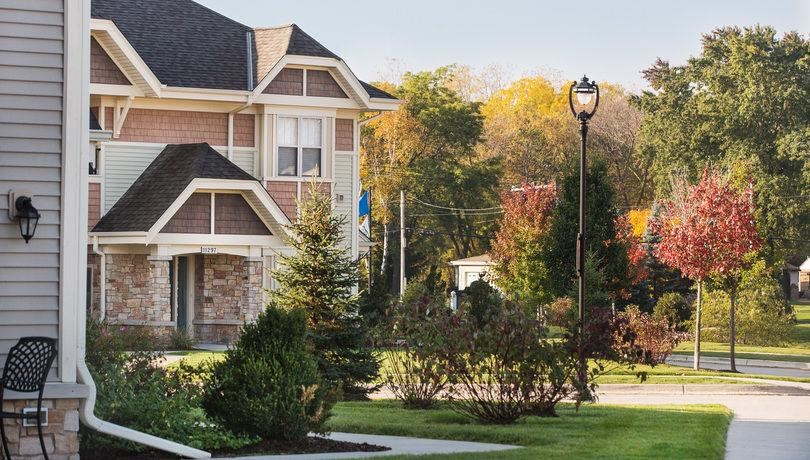 a house on the side of a street with trees