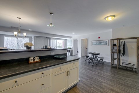 a kitchen with a counter top and a dining room with a table and chairs