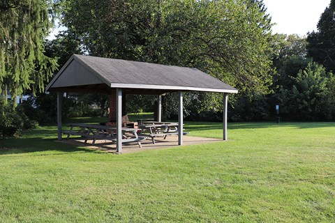 a pavilion with picnic tables in a park