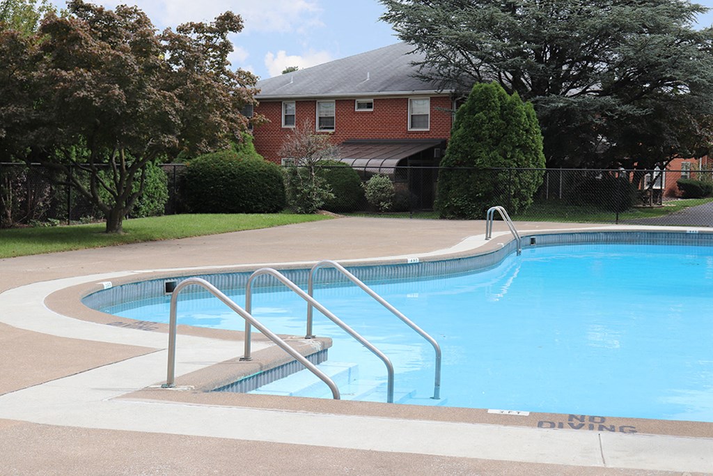 a swimming pool with a house in the background