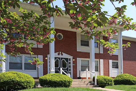 the front of a brick building with steps and a porch