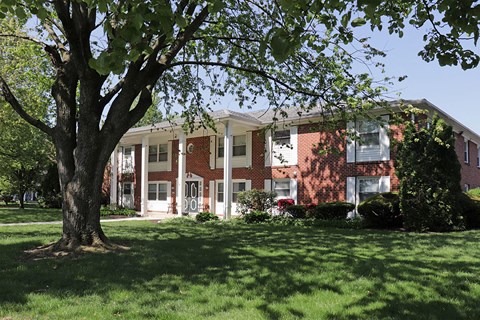 a large brick building with a tree in front of it