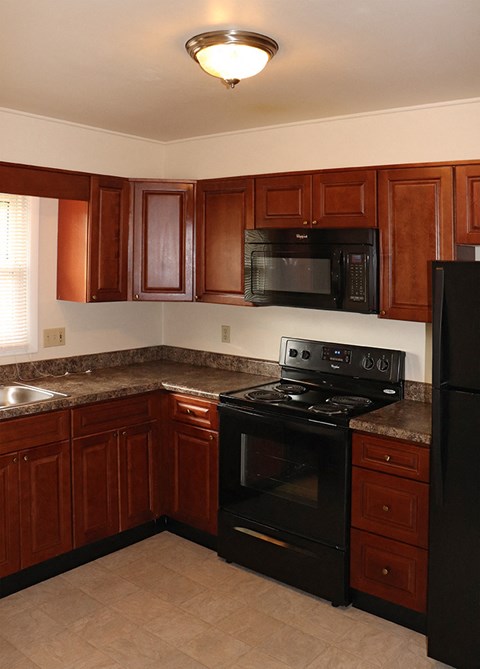 a kitchen with black appliances and wooden cabinets