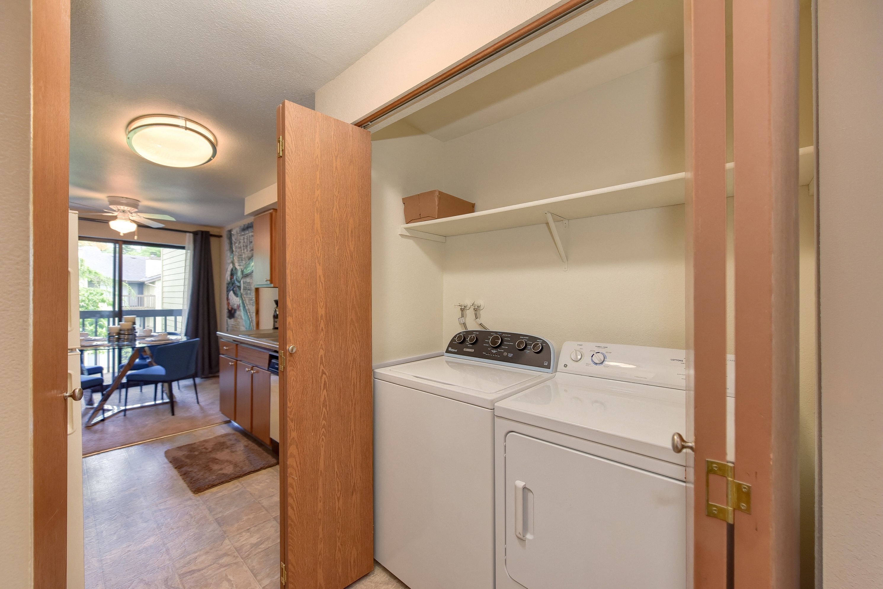 In Unit Washer and Dryer, Wood Cabinets, Shelves and View of Dining Room