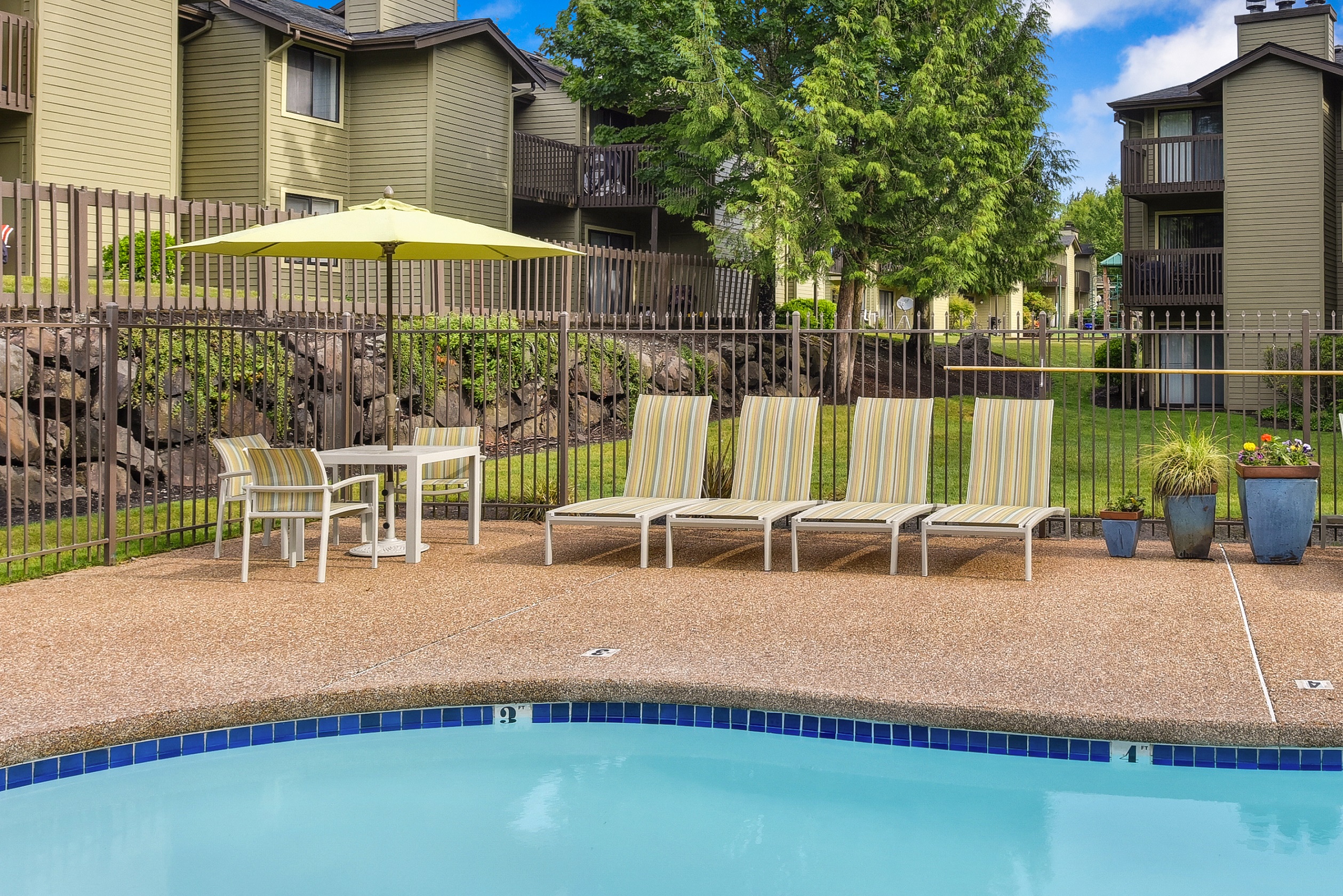 Outdoor Swimming Pool Lounge Area, Lounge Chairs, Umbrella and Building Exteriors