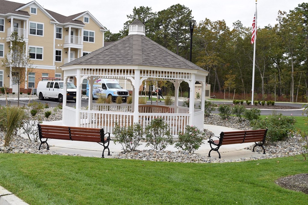 a gazebo in the middle of a park with benches