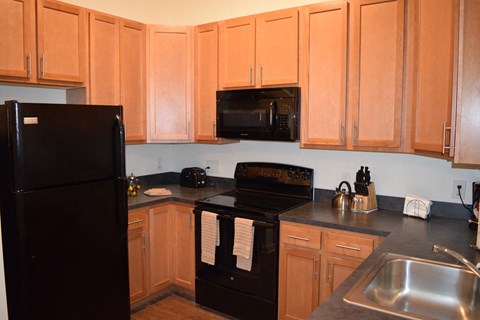 a kitchen with black appliances and wooden cabinets