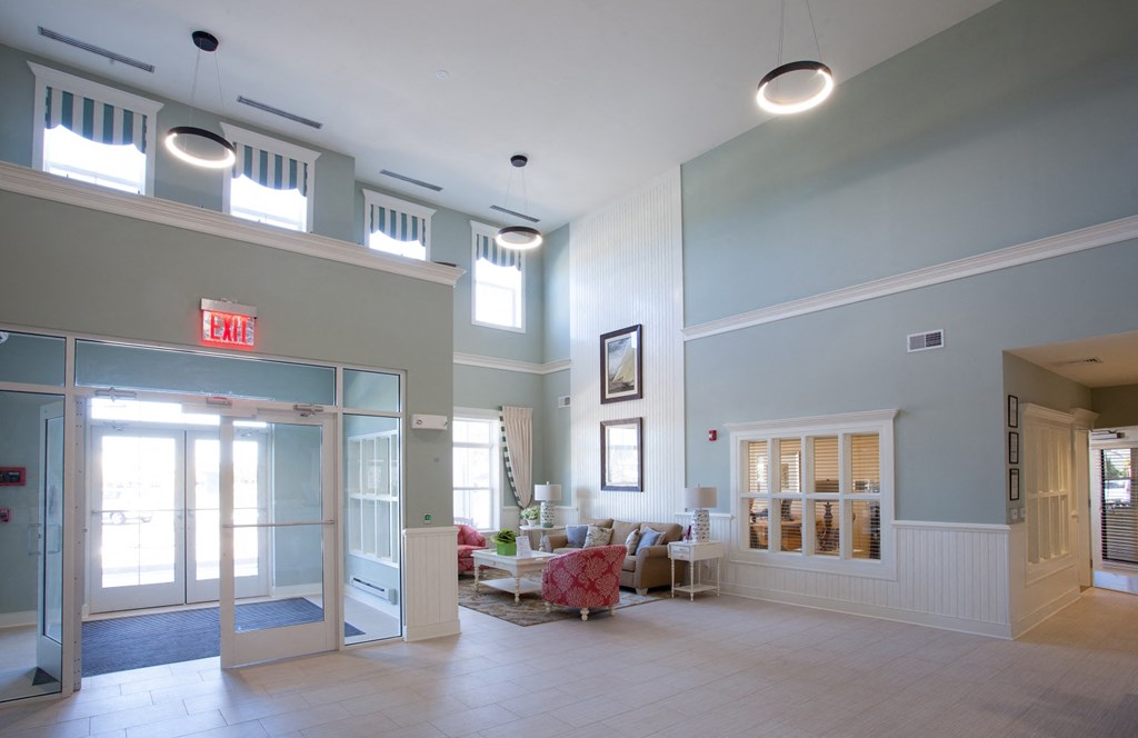 a lobby with a seating area and a door into a building